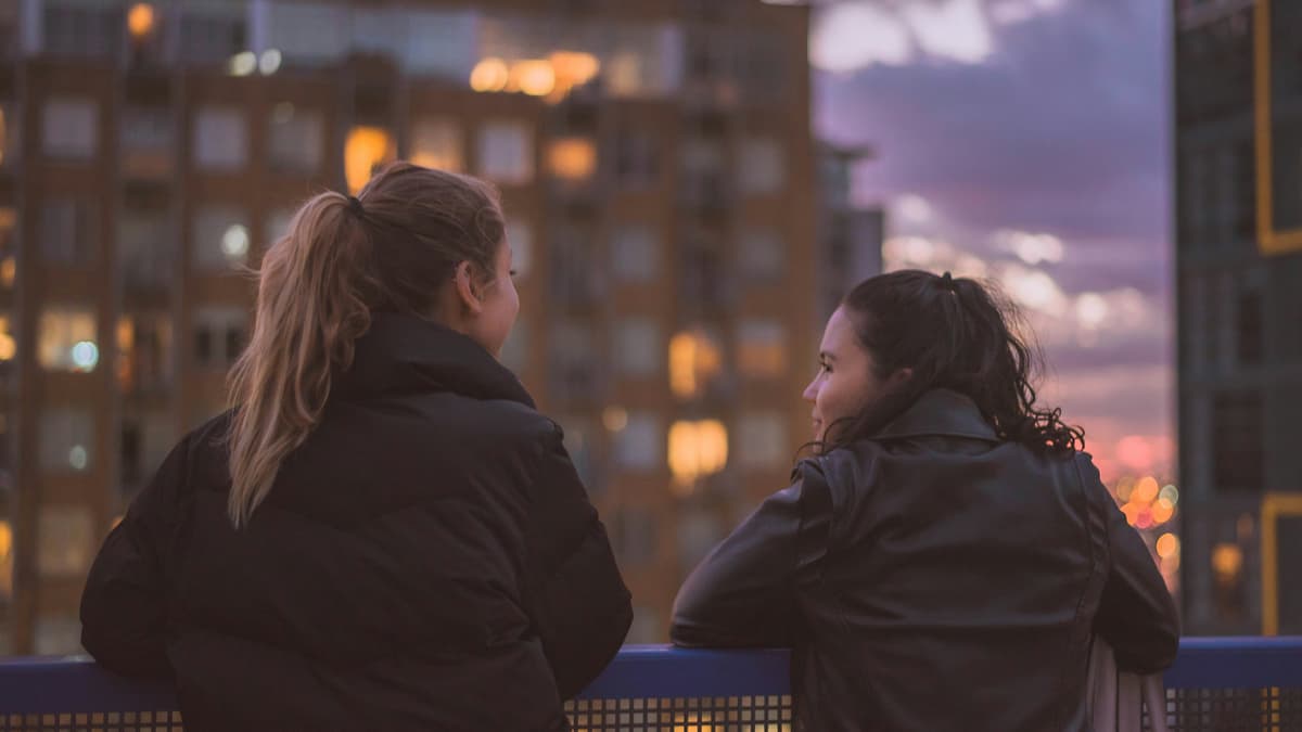 Two girls chatting on a balcony
